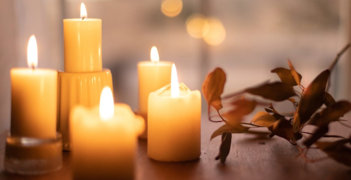 white pillar candles on brown wooden table
