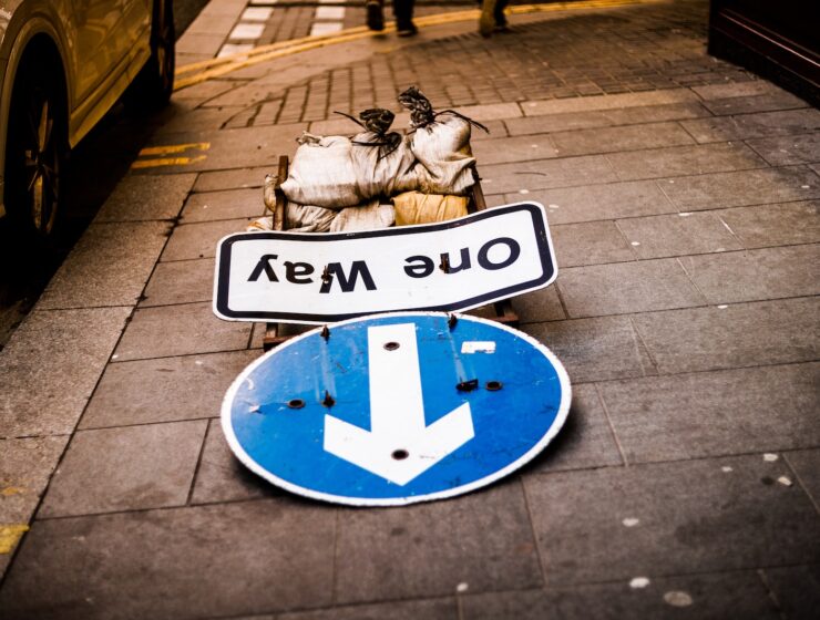 a blue and white street sign sitting on the side of a road
