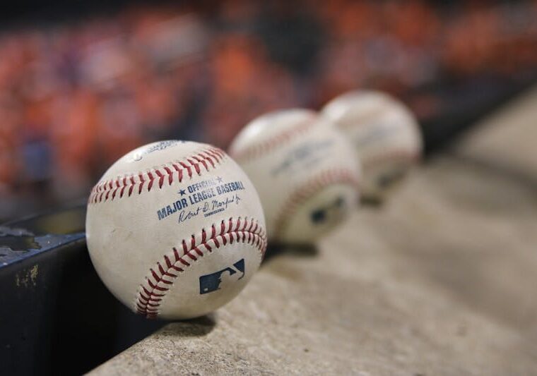 three white baseballs on gray textile